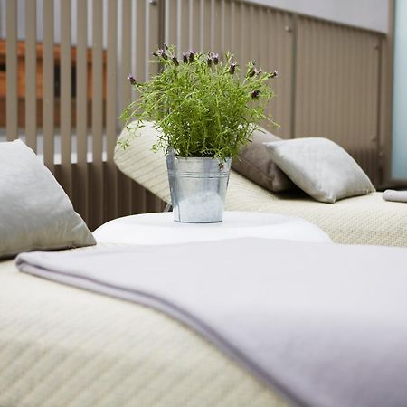 Steigenberger Hotel Am Kanzleramt Βερολίνο Δωμάτιο φωτογραφία The photo shows two lounge chairs with soft, light-colored cushions. Between them, there is a small round table featuring a metal bucket filled with greenery. The setting appears to be designed for relaxation, with a clean and modern aesthetic, likel