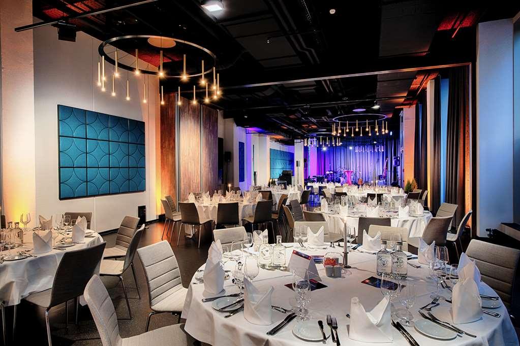 Steigenberger Hotel Am Kanzleramt Βερολίνο Ανέσεις φωτογραφία The photo shows a modern dining room setup, likely for an event or dinner. Several round tables are elegantly arranged with white tablecloths and neatly folded napkins, suggesting a formal dining experience. Each table is equipped with glasses and cu