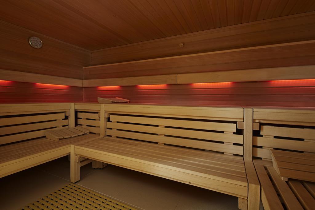 Steigenberger Hotel Am Kanzleramt Βερολίνο Εξωτερικό φωτογραφία The photo shows the interior of a sauna. The walls and benches are made of light-colored wood, creating a warm and natural atmosphere. There are horizontal wooden slats forming the benches, which are arranged for seating. Soft red lighting is install